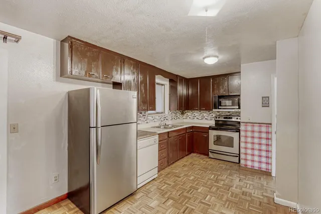 a kitchen with stainless steel appliances granite countertop a refrigerator sink and stove