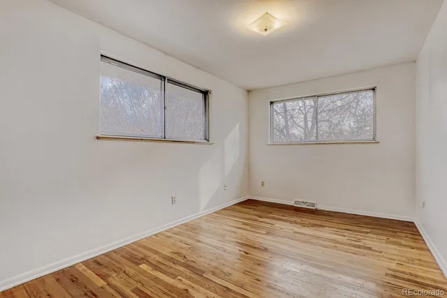 a view of empty room with wooden floor
