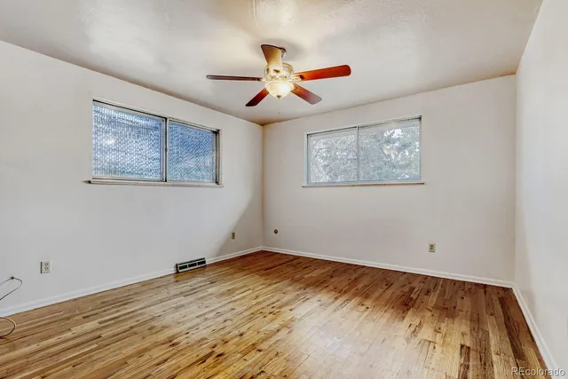 a view of empty room with wooden floor