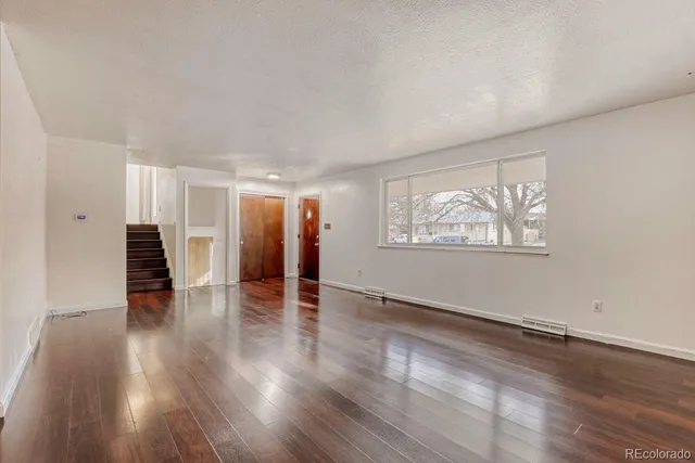 an empty room with wooden floor and closet