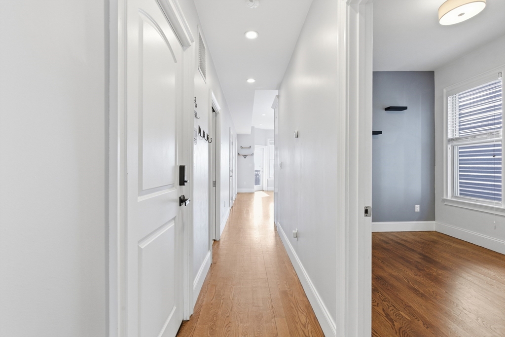249 Lexington Street, Unit 2 Boston, MA 02128 - Photo 13 of 24 a view of a hallway with wooden floor and a bathroom