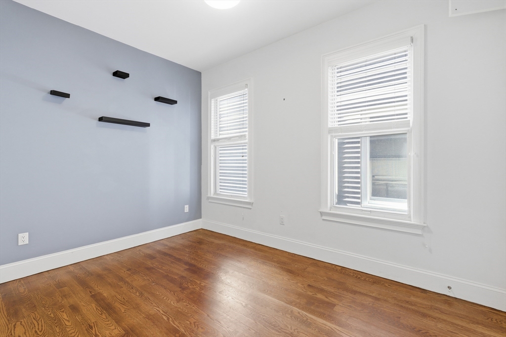249 Lexington Street, Unit 2 Boston, MA 02128 - Photo 14 of 24 an empty room with wooden floor and windows