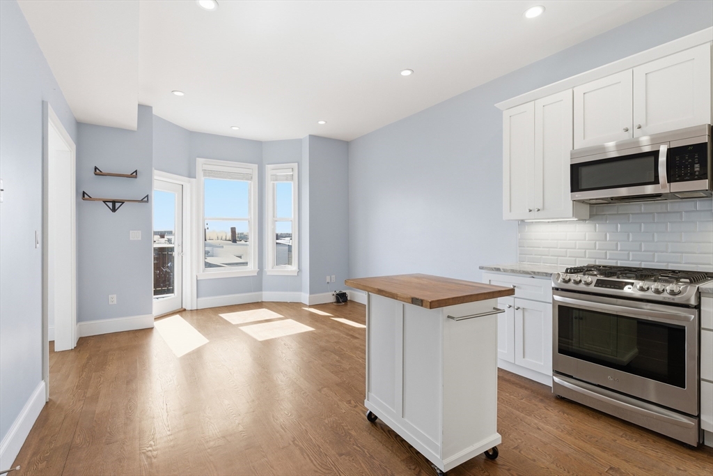 249 Lexington Street, Unit 2 Boston, MA 02128 - Photo 8 of 24 a kitchen with granite countertop a stove and a refrigerator