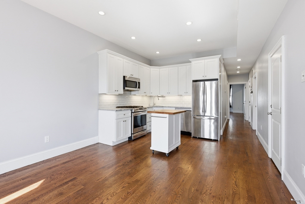 249 Lexington Street, Unit 2 Boston, MA 02128 - Photo 9 of 24 a kitchen with stainless steel appliances a refrigerator and a stove top oven