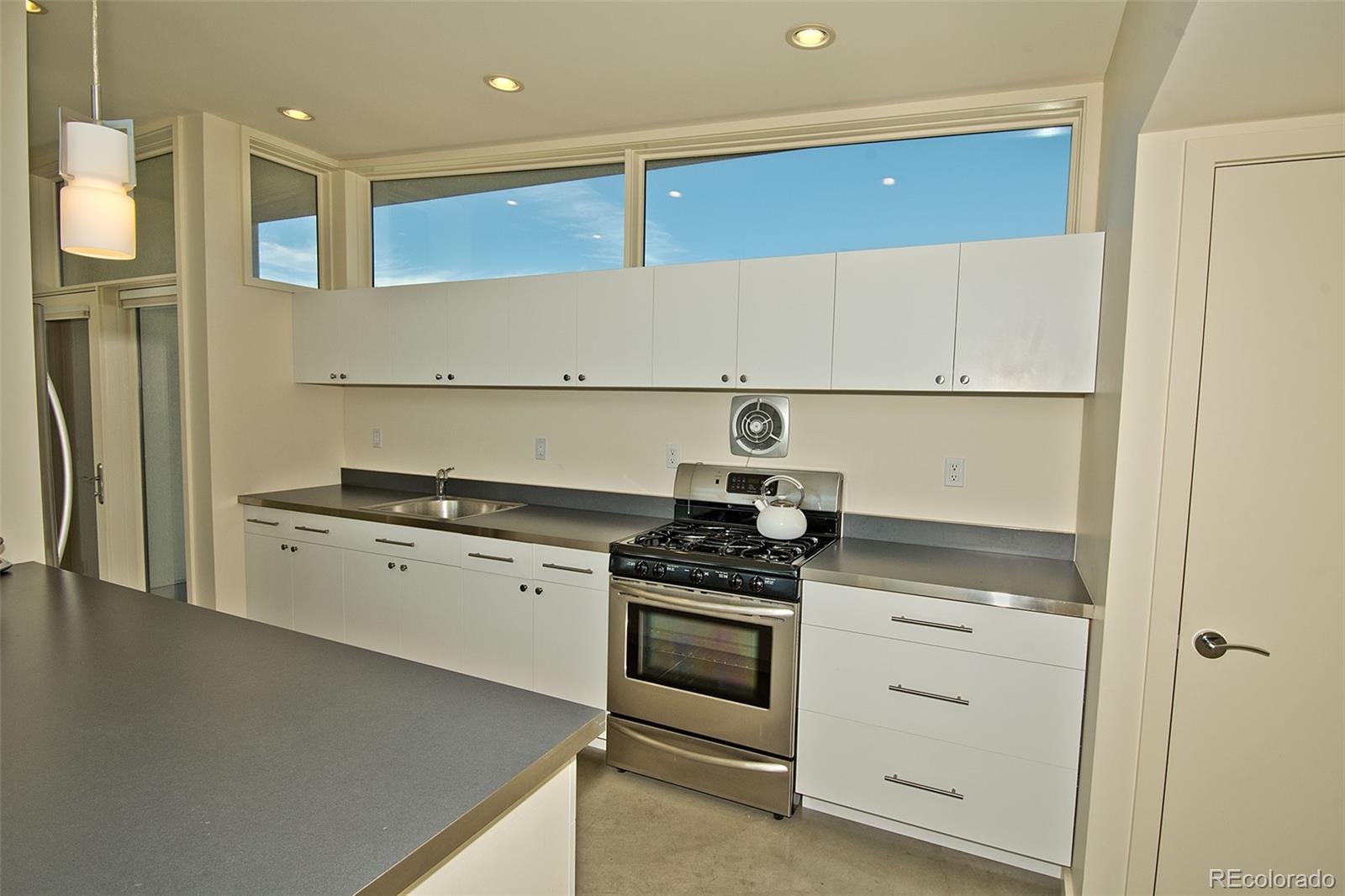 790 Birch Road Crestone, CO 81131 - Photo 15 of 38 a kitchen with stainless steel appliances granite countertop a stove and a refrigerator
