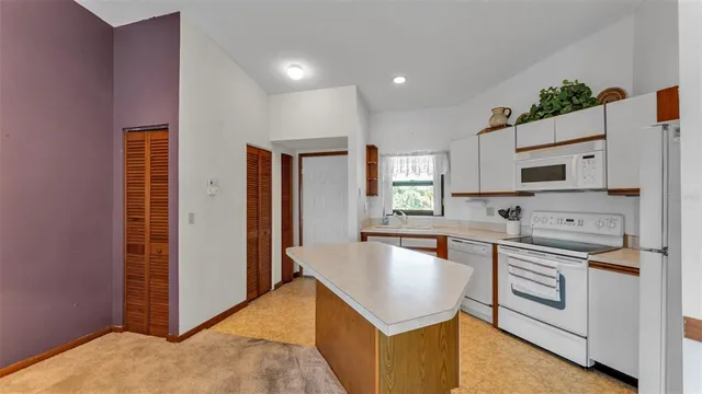 a kitchen with kitchen island a stove a sink and a refrigerator