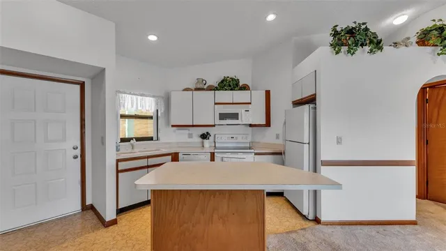 a kitchen with stainless steel appliances a stove a sink cabinets and a refrigerator