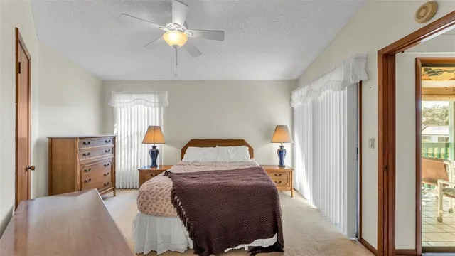 a bedroom with a bed a chandelier and a large window