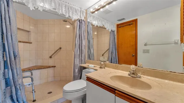 a bathroom with a sink toilet double vanity and shower