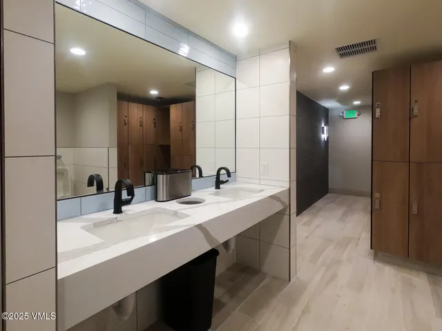 a bathroom with double vanity sinks and a mirror