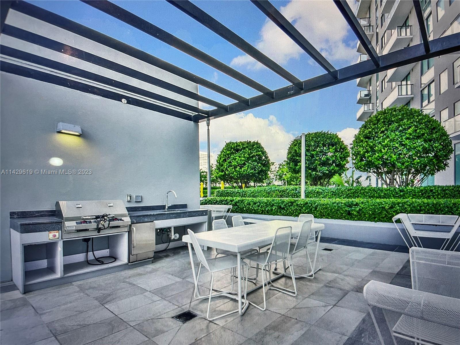 Paraiso Bayviews Miami, FL 33137 - Photo 2 of 5 a view of a patio with a dining table and chairs with a wooden fence