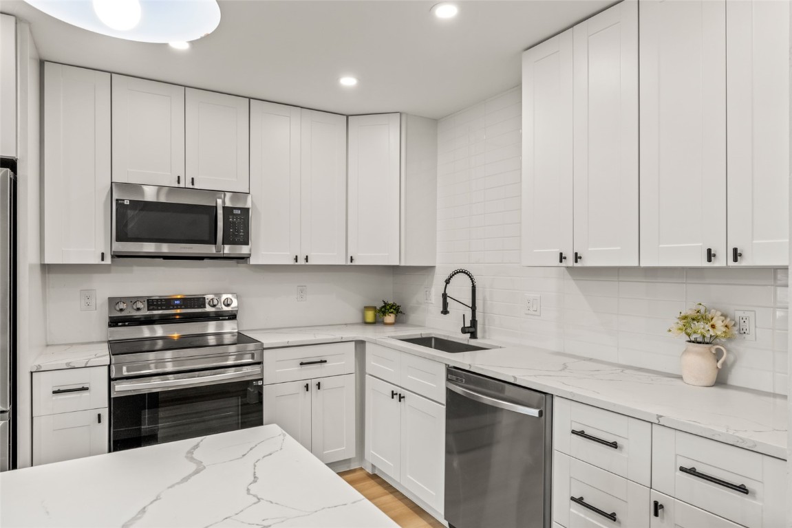 1375 Walton Creek Road, Unit 7 Steamboat Springs, CO 80487 - Photo 7 of 21 a kitchen with granite countertop white cabinets and stainless steel appliances