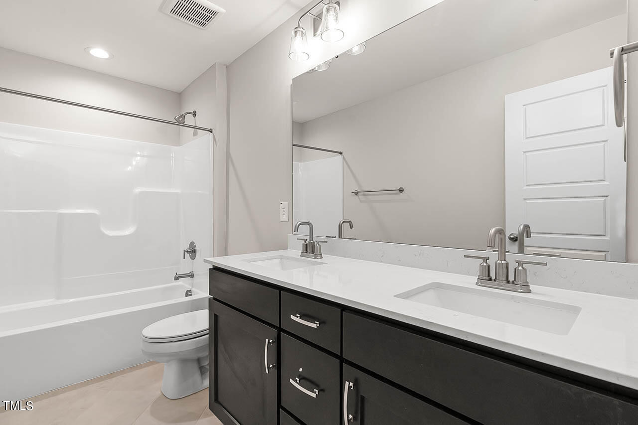 138 Rawhide Drive Spring Hope, NC 27882 - Photo 15 of 32 a bathroom with a granite countertop sink a toilet a shower and a mirror