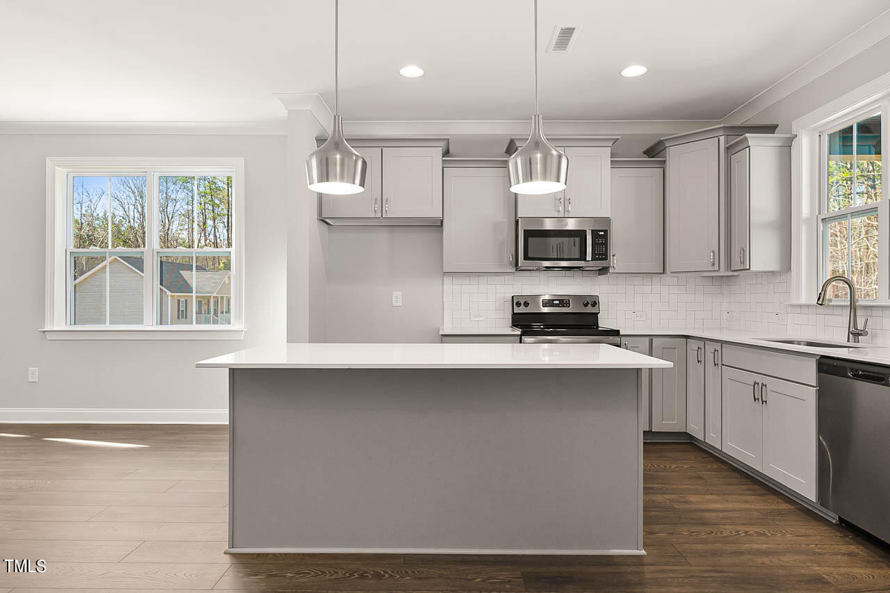 138 Rawhide Drive Spring Hope, NC 27882 - Photo 2 of 32 a kitchen with kitchen island granite countertop a sink cabinets and stainless steel appliances