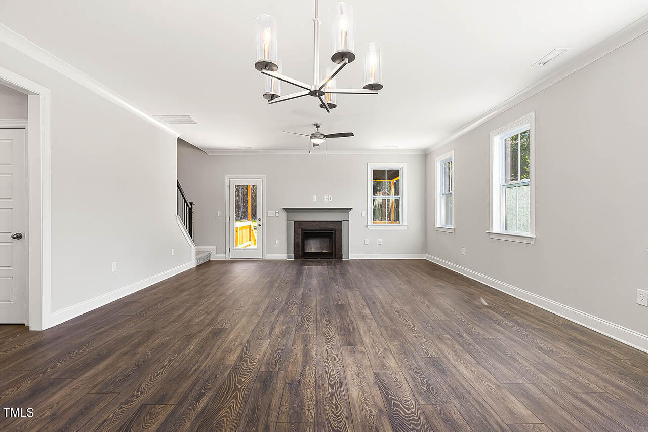 138 Rawhide Drive Spring Hope, NC 27882 - Photo 5 of 32 an empty room with windows fireplace and a ceiling fan