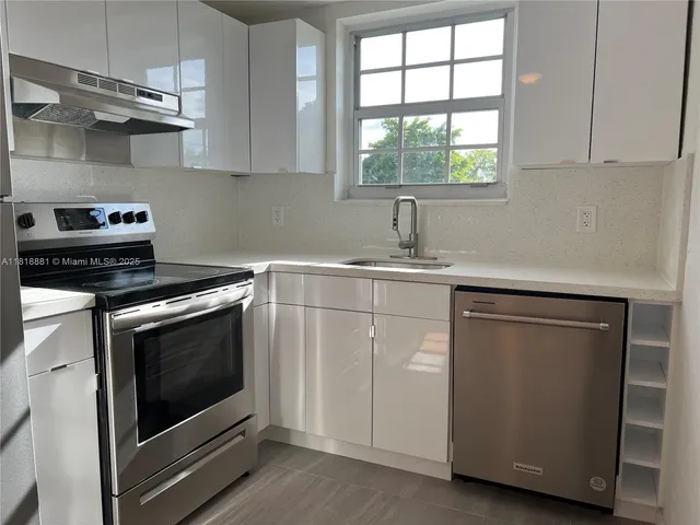 a kitchen with white cabinets stainless steel appliances and sink