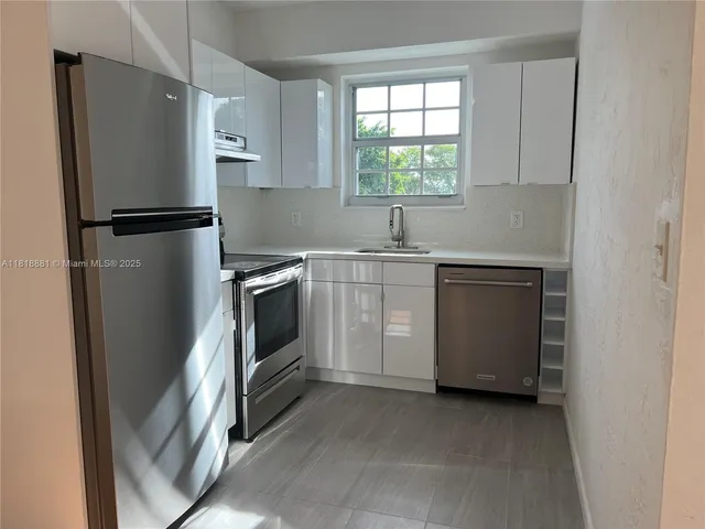 a kitchen with a refrigerator sink and window
