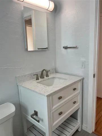 a bathroom with a sink toilet and mirror
