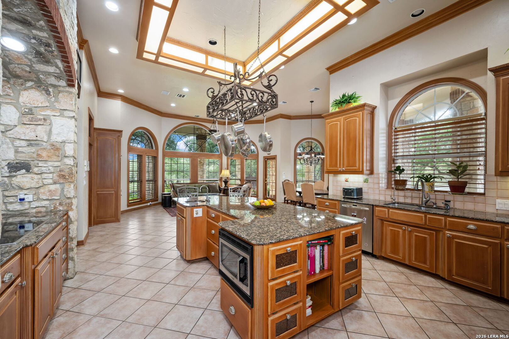 8040 Rolling Acres Trail Fair Oaks Ranch, TX 78015 - Photo 11 of 50 a kitchen with stainless steel appliances granite countertop a stove and a view of living room
