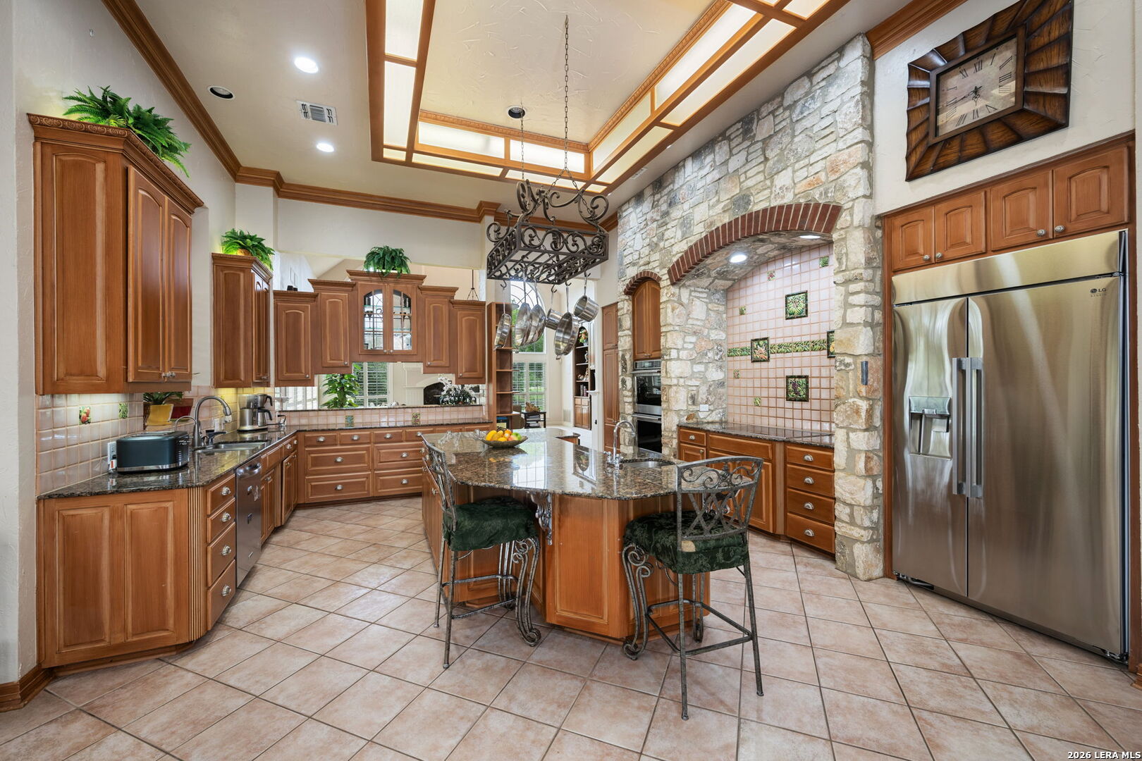 8040 Rolling Acres Trail Fair Oaks Ranch, TX 78015 - Photo 12 of 50 a kitchen with stainless steel appliances kitchen island granite countertop a refrigerator a stove and a refrigerator with wooden cabinets