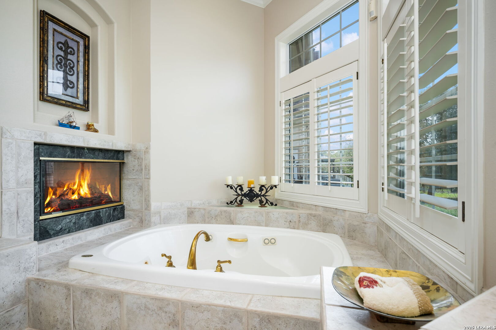 8040 Rolling Acres Trail Fair Oaks Ranch, TX 78015 - Photo 27 of 50 a bathroom with a tub a window and a fireplace