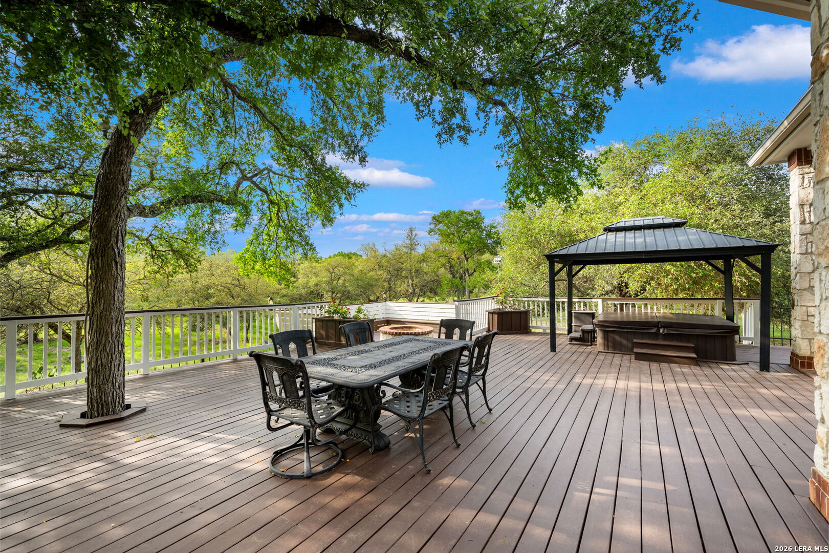 8040 Rolling Acres Trail Fair Oaks Ranch, TX 78015 - Photo 41 of 50 a view of a deck with table and chairs and wooden floor