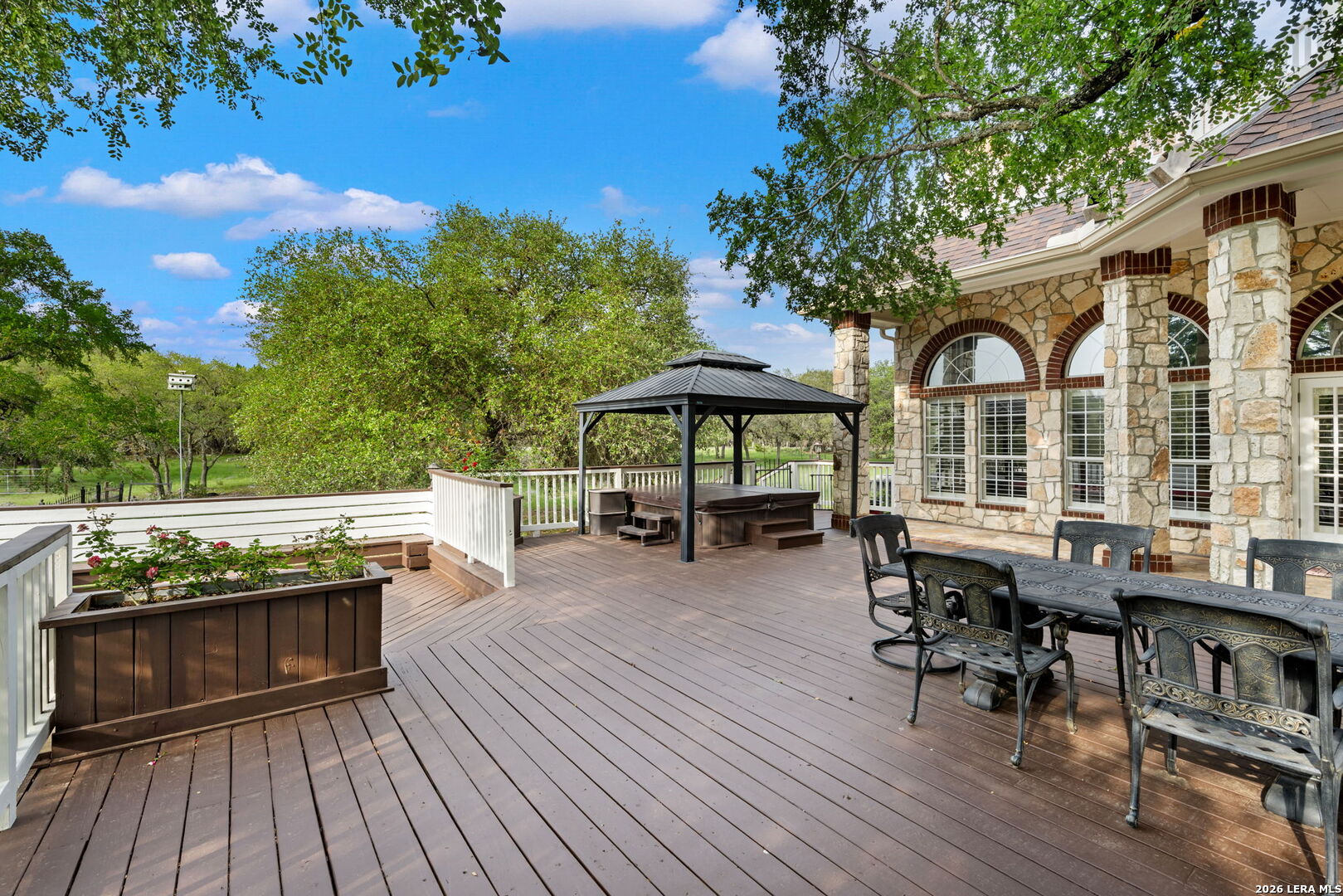 8040 Rolling Acres Trail Fair Oaks Ranch, TX 78015 - Photo 42 of 50 a view of a patio with table and chairs and wooden floor