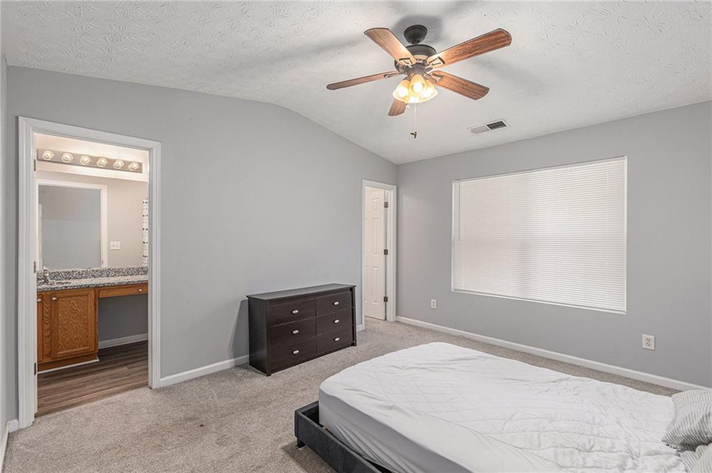 6536 Arbor Gate Drive Southwest, Unit 2 Mableton, GA 30126 - Photo 18 of 27 a bedroom with a bed and a ceiling fan