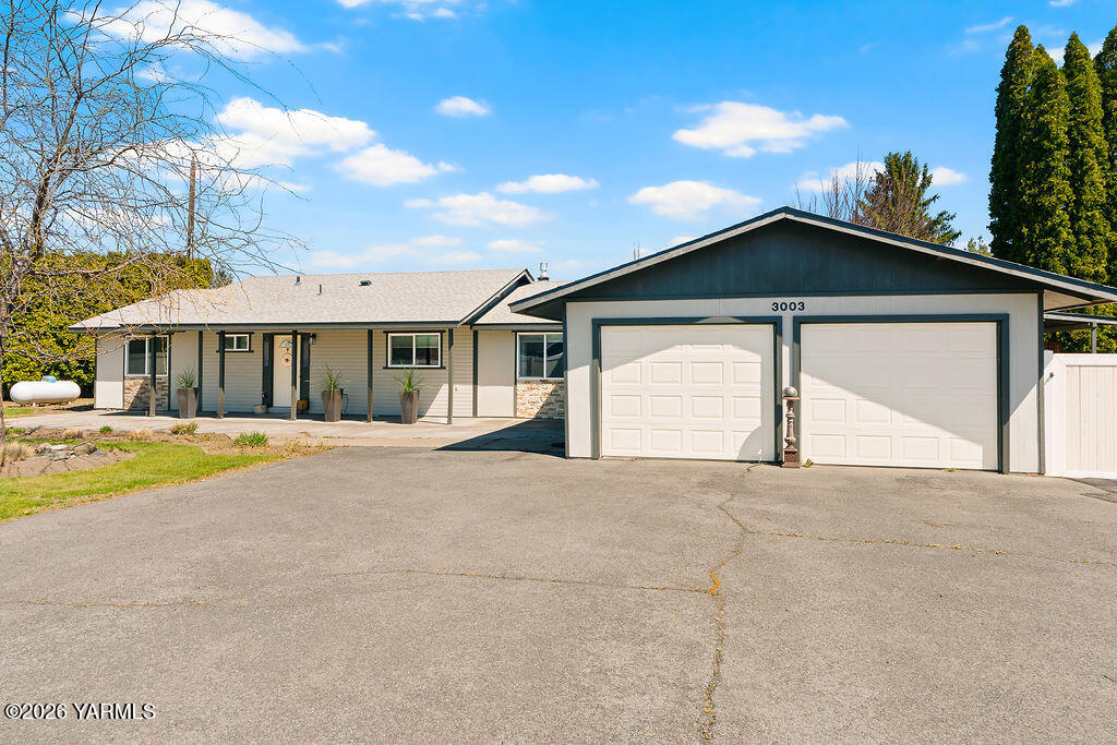 3003 South 79th Avenue Yakima, WA 98903 - Photo 1 of 32 a front view of a house with a yard and garage