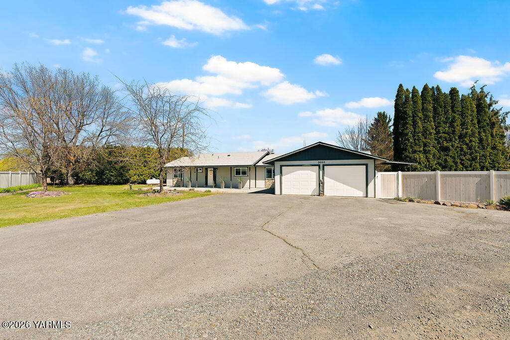 3003 South 79th Avenue Yakima, WA 98903 - Photo 29 of 32 a front view of a house with a yard and garage
