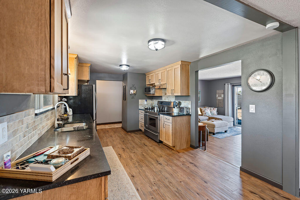 3003 South 79th Avenue Yakima, WA 98903 - Photo 8 of 32 a kitchen with a refrigerator and a stove top oven