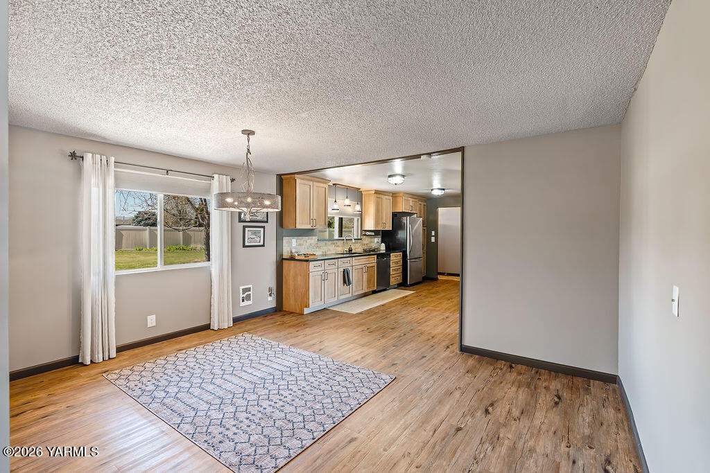 3003 South 79th Avenue Yakima, WA 98903 - Photo 9 of 32 a view of a kitchen with wooden floor and a refrigerator