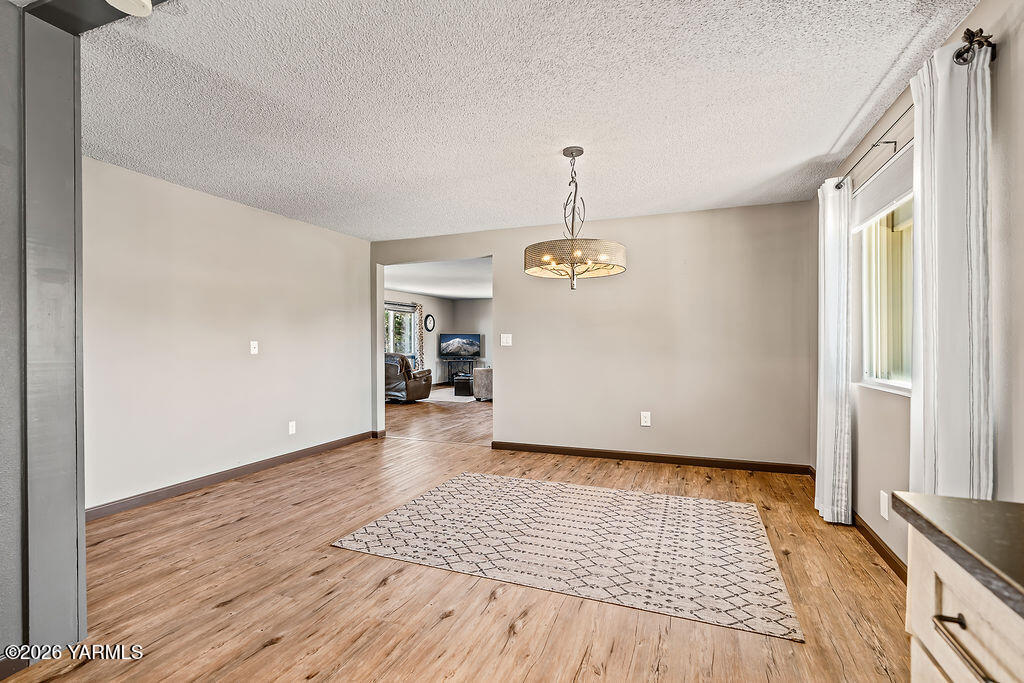 3003 South 79th Avenue Yakima, WA 98903 - Photo 10 of 32 a view of empty room with wooden floor and window
