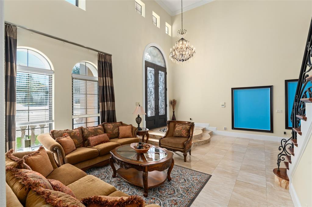 9575 Westover Roberts Road Windermere, FL 34786 - Photo 25 of 95 a living room with furniture chandelier and a large window