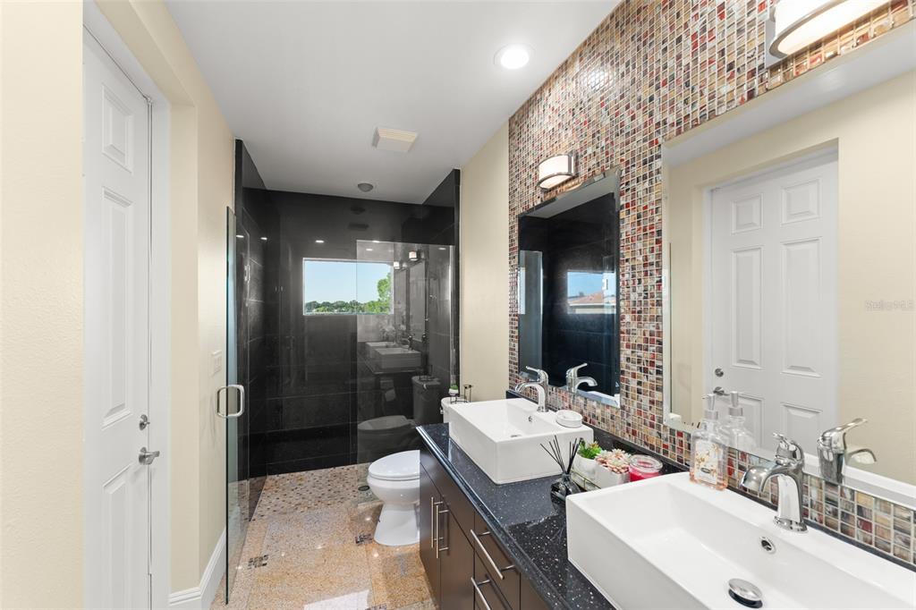 9575 Westover Roberts Road Windermere, FL 34786 - Photo 43 of 95 a bathroom with double vanity sinks a toilet a shower and a mirror