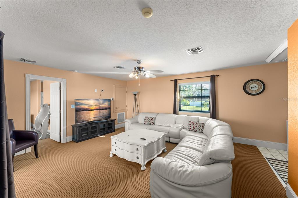 9575 Westover Roberts Road Windermere, FL 34786 - Photo 62 of 95 a living room with furniture a fireplace and a flat screen tv