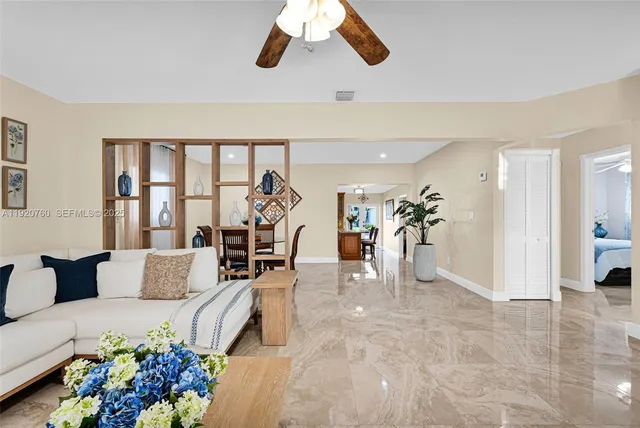 a kitchen with stainless steel appliances granite countertop a stove top oven a sink a refrigerator with a dining table and chairs with wooden floor