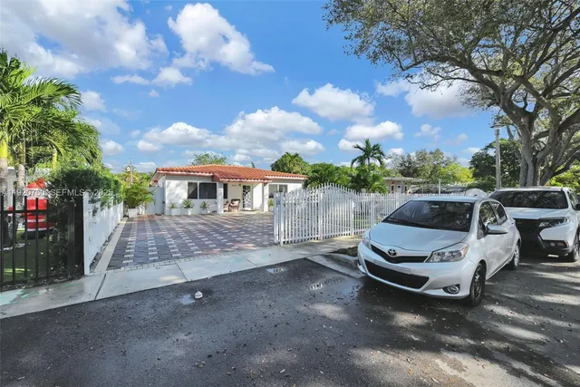 a view of a house with backyard and trees