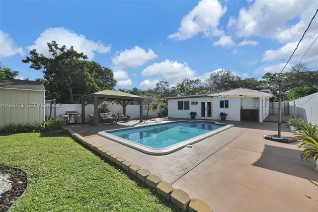 an aerial view of residential houses with outdoor space and ocean view