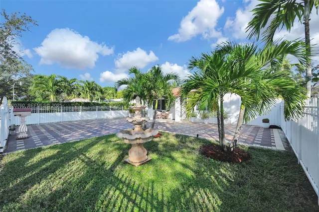 a kitchen with stainless steel appliances granite countertop a refrigerator a stove a sink a dining table and chairs with wooden floor