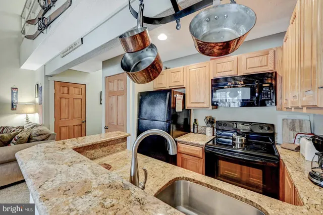a living room with furniture kitchen area and a window