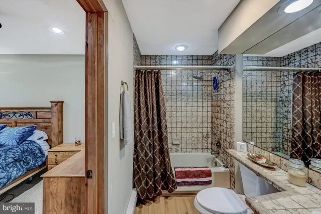 a bedroom with a bed and a dresser with mirror