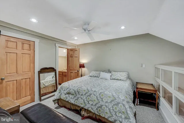 a bedroom with a bed and a dresser with mirror