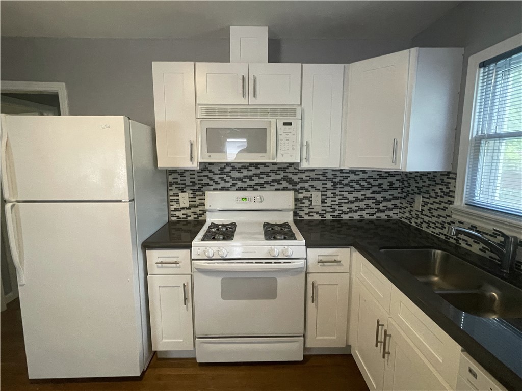 1041 Rosemont Street Austin, TX 78723 - Photo 5 of 13 a white kitchen with sink a refrigerator and a stove