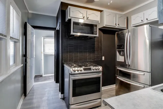 a kitchen with granite countertop stainless steel appliances and wooden cabinets