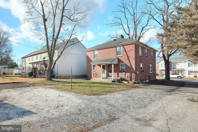 a view of a house with a yard and large tree