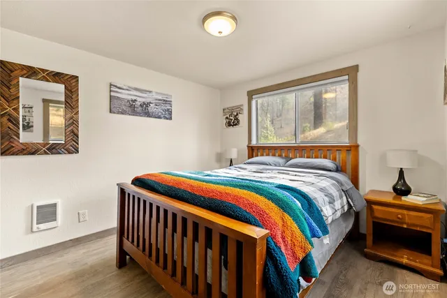 a bedroom with bed and wooden floor