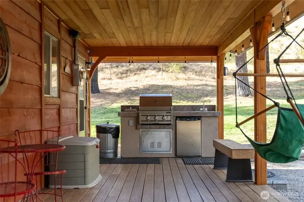 a view of a patio with wooden floor next to a yard