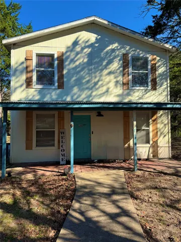 a living room with lots of furniture and view of kitchen