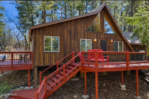a view of a house with wooden deck and furniture